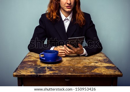 woman in suit with digital reader in coffee shop