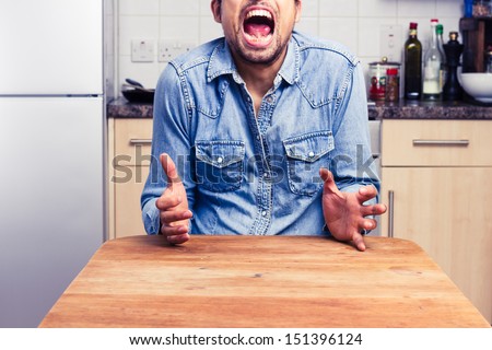 Screaming man gesturing with hands in his kitchen