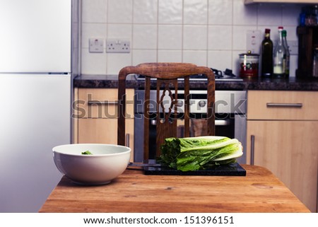 Kitchen table with chopping board and salad