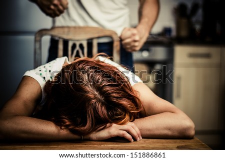 Crying woman with abusive partner behind her