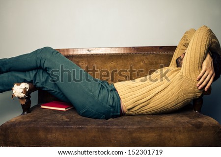 Young man sleeping on old sofa