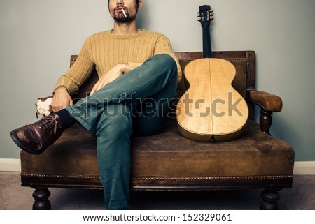 Musician sitting on old sofa smoking