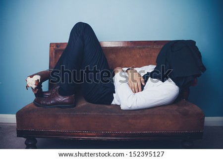 Businessman sleeping on old sofa