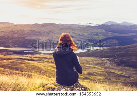 Woman Looking At The Sunset Over Mountains