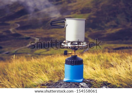 Gas stove with pot of boiling water in the mountains