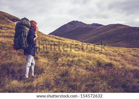 Woman with backpack about to climb mountain