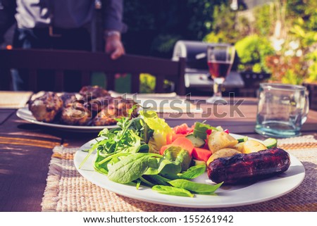 Salad, sausage and chicken at family barbecue