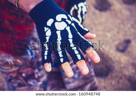 Woman wearing skeleton glove on the beach