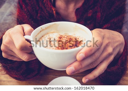 Woman in wool jumper drinking coffee on cold day