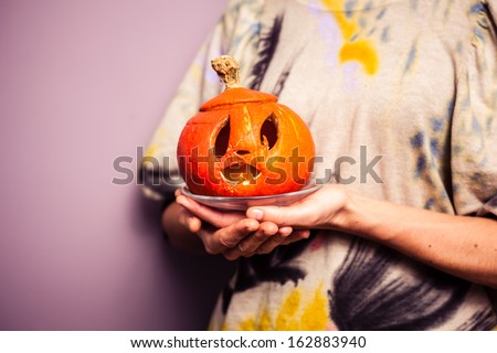 Young woman holding a scary jack-o-lantern