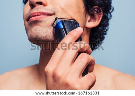 Man shaving with electric razor