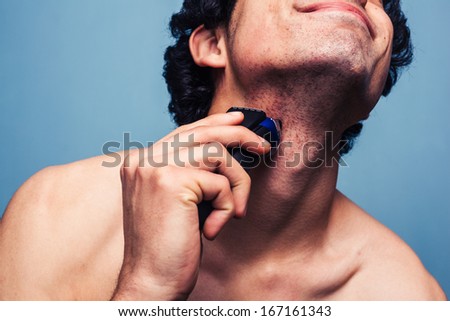 Man shaving with electric razor