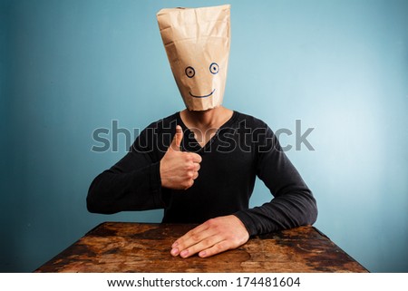 Man with bag over head giving thumbs up