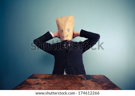 Businessman with bag over head relaxing