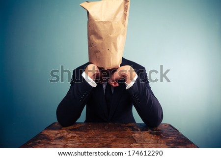 Sad businessman with bag over his head