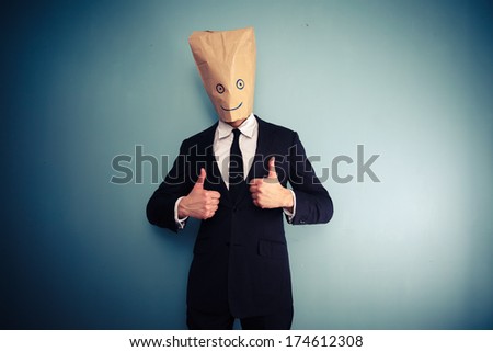 Businessman with bag over head giving two thumbs up