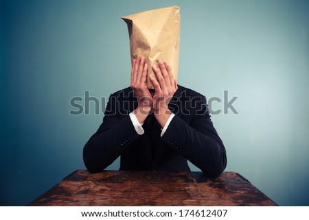 Upset businessman with bag over his head