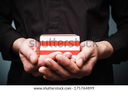 Close up on a man\'s hands as he is holding a small present