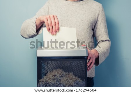 Man is shredding a piece of paper