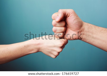 Young man and woman are fist bumping