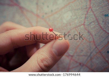 Close up on a hand placing a pin on a map