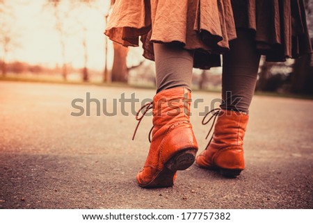 Closeup on a woman\'s feet as she is walking in the park on a sunny day