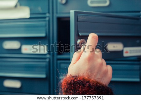 Closeup on a woman\'s hand as she is getting her post out of her letterbox