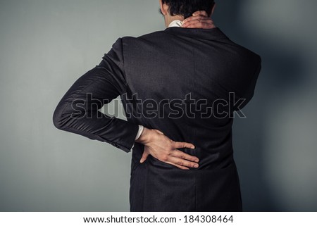 Young businessman with a sore neck and back