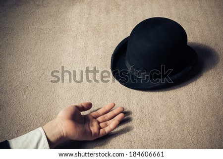 A man is lying dead on the floor with his hat next to him