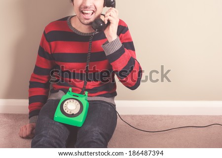Happy young man is talking on the telephone