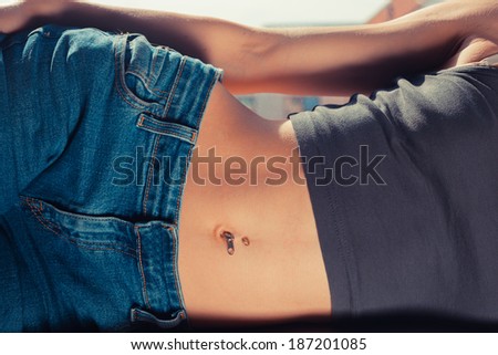Young woman with a flat stomach is lying on the window sill