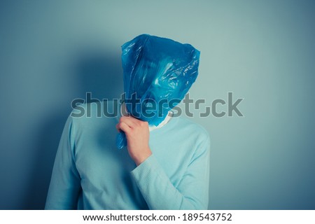 A man with a plastic bag over his head is suffocating