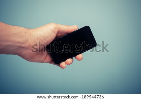 A hand is holding a black smart phone