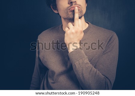 Young man is displaying an obscene gesture