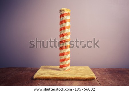 A cat\'s scratching post against a purple background