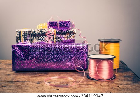 Presents on a wooden table with roll of ribbon