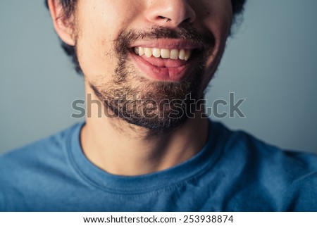 A young man with a beard is pulling silly faces