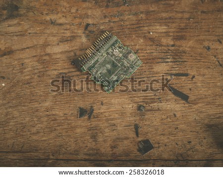 A smashed computer chip on a wooden desk