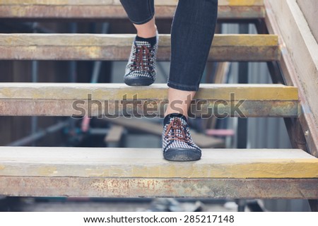 The feet of a young woman as she is walking down some wooden steps