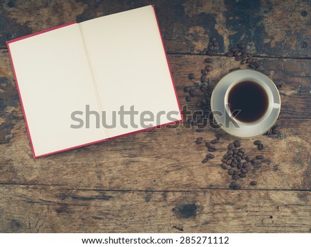 Overhead shot of coffee concept with empty cup, tea towel and an open book with blank pages