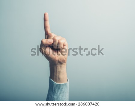 A male hand with the index finger pointing up