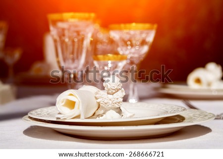 An elegant dining table setting with napkin and win glasses outdoors