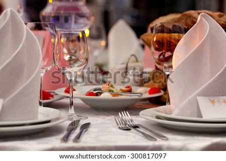 Wine glasses, napkins and salad on the table for the banquet.