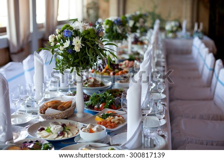 Served for a banquet table. Wine glasses with napkins, glasses and salads.
