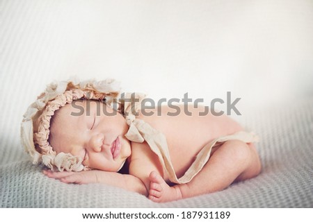 Portrait of Newborn Baby Sleeping in Subtile Hat on Soft Blanket