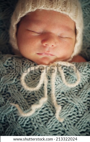 Newborn Baby in Wrap and Red Blanket