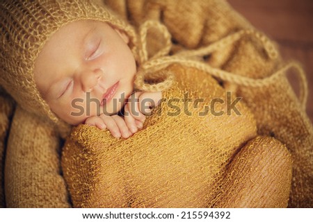 Sleeping Newborn Baby in Hat - close portrait with hands, Wrap and Hat