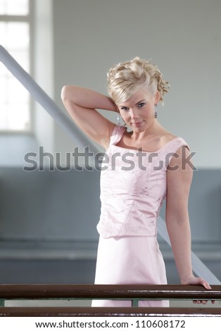 Portrait of a woman dressed in pink, posing at the dance floor.