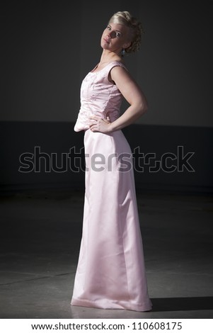 Portrait of a woman dressed in pink, posing at the dance floor.