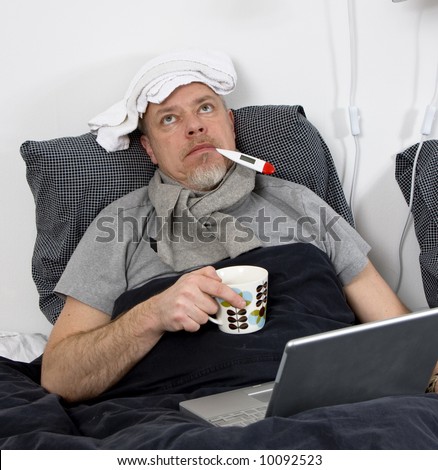 man laying in bed, sick with thermometer in mouth
